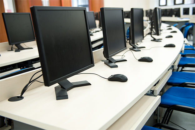 Group of computer neatly placed in a computer lab.
