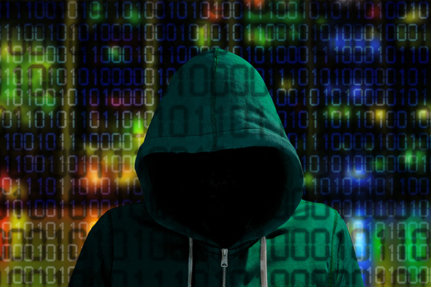 Hacker in a green hoody standing in front of a colored server background with binary streams cybersecurity concept